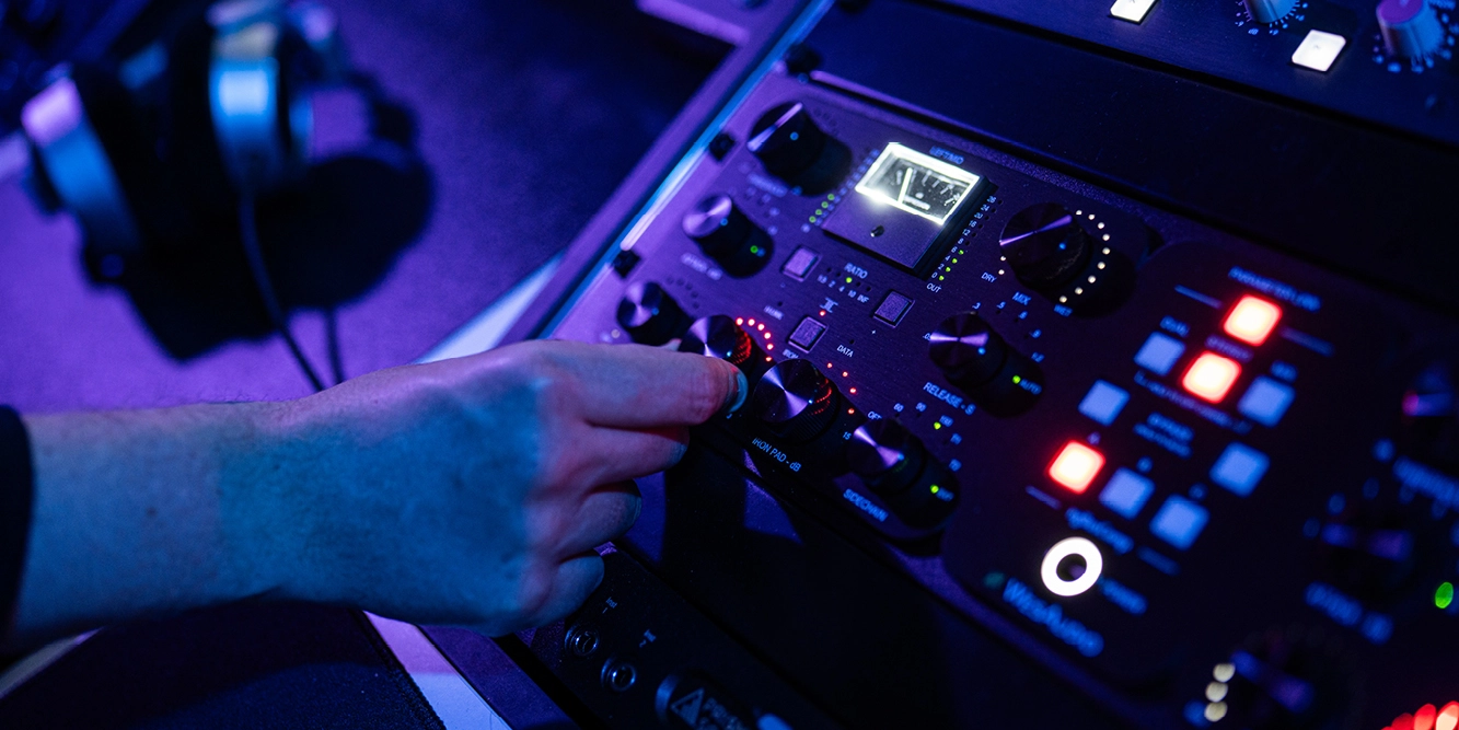 Student stelt de threshold in op een analoge compressor tijdens producerles